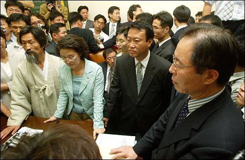 민주노동당 의원등이 23일 국회 통일외교통상위에 상정될 예정인 쌀 관세화 유예협상 비준동의안의 상정 및 심의를 저지하기 위해 국회 통외통위 회의실을 점거해, 열린우리당 의원 보좌진등과 몸싸움이 벌어졌다. 민주노동당 의원들이 위원장석을 둘러싼채 쌀협상비준동의안 상정을 반대하고 있다. 